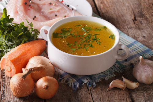 Foto Chicken broth and ingredients on the table close-up. horizontal