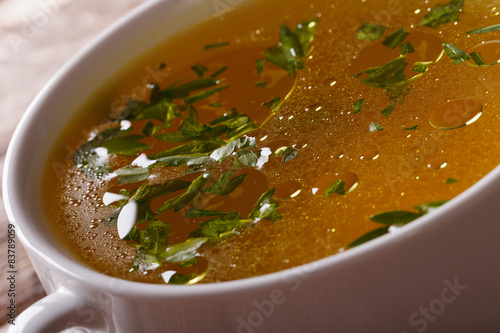Photos Tasty meat broth with parsley macro. horizontal