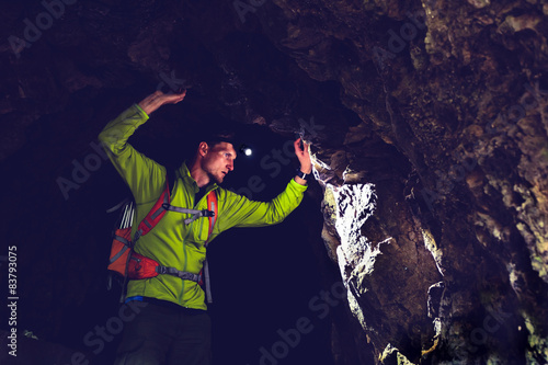 Man exploring underground dark cave tunnel
