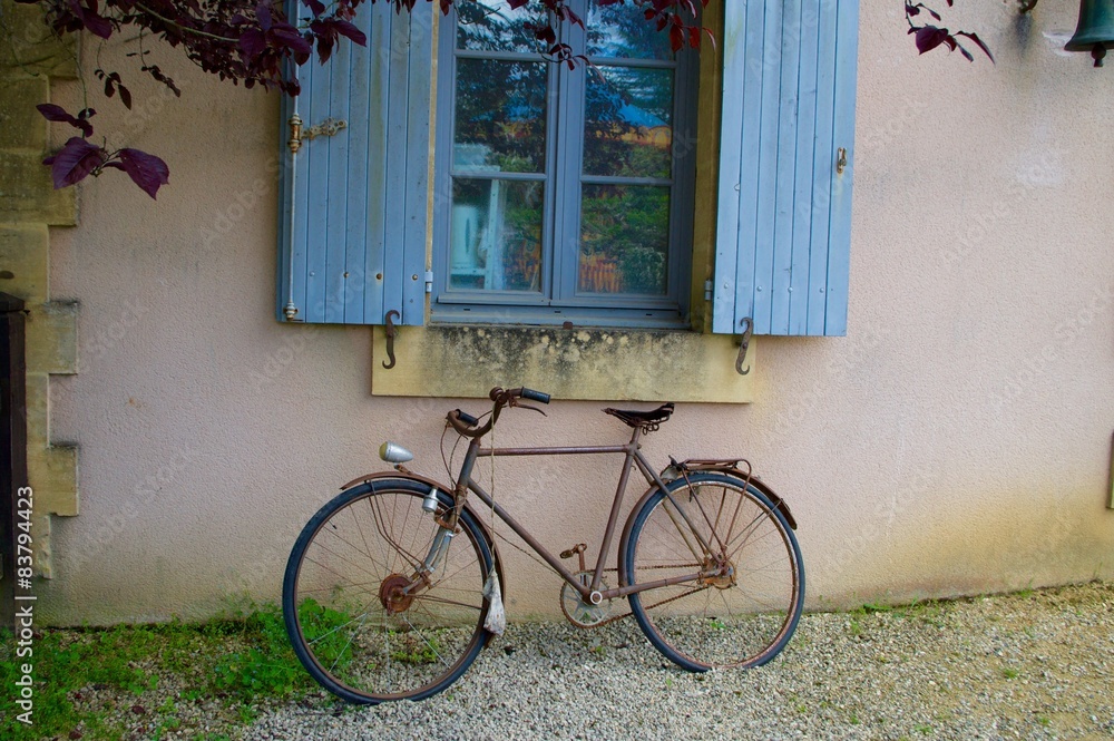 Vieux vélo sur un mur de maison