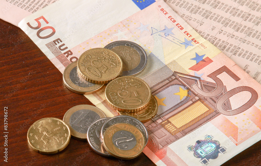 Money: euro coins and bills close up isolated on wood background Money: euro coins and bills close up isolated on wood background