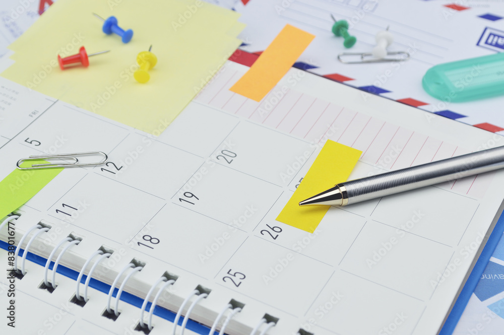 Pencil with post It notes and pin on business diary page