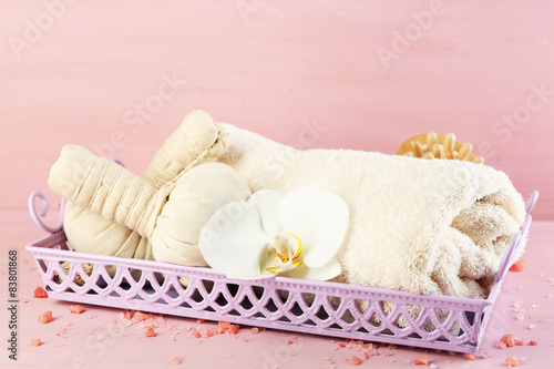 Still life with beautiful blooming orchid flower, spa treatment on tray, on color wooden background