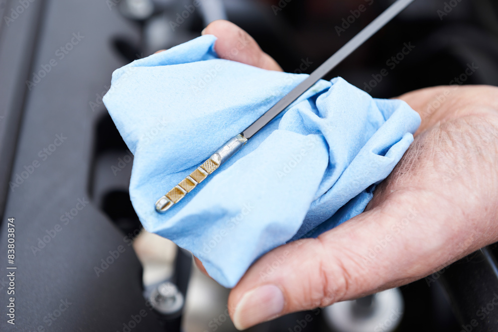 Close-Up Of Man Checking Car Engine Oil Level On Dipstick Close-Up Of Man Checking Car Engine Oil Level On Dipstick
