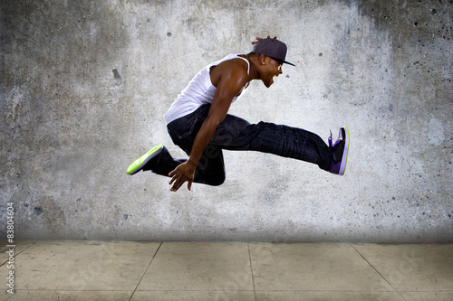 Fototapeta hip hop dancer jumping high on concrete