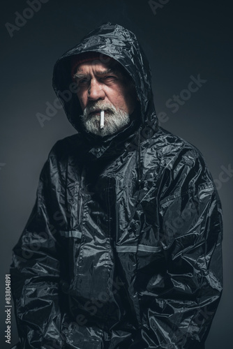 Reflective Man in Jacket Smoking a Cigarette