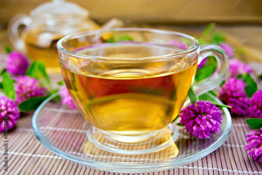 Tea with clover in cup on bamboo Tea with clover in cup on bamboo