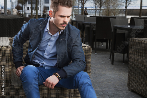 Obraz na płótnie Man sitting on rattan chair w salonie