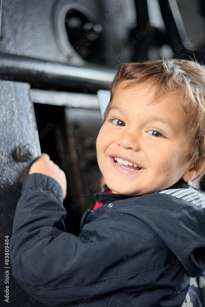 Child plays curiously observing the inside of the boiler of old Child plays curiously observing the inside of the boiler of old