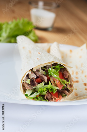Tortilla with a delicious grilled meat and fresh mixed leafy gre