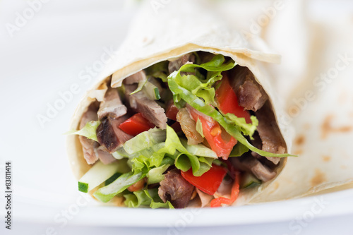 Tortilla with a delicious grilled meat and fresh mixed leafy gre