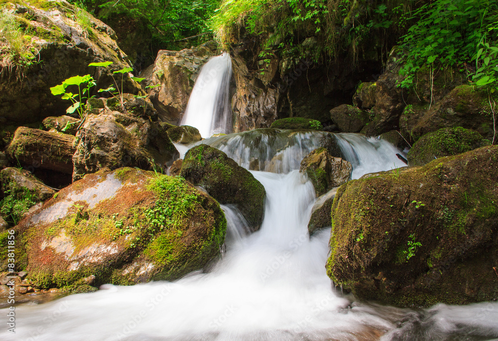 Fototapeta premium Beautiful small waterfall landscape in the mountains.
