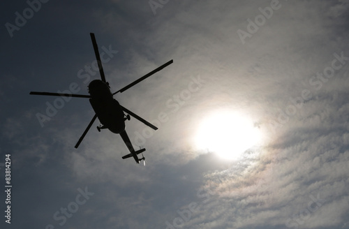 Helicopter silhouette sun above