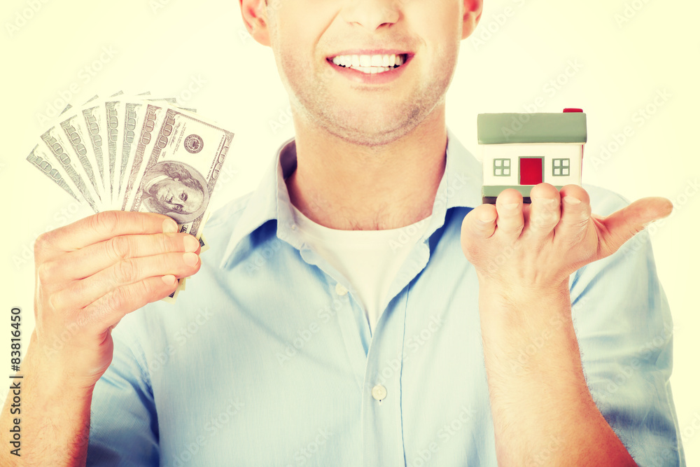 Construction man holding house model and money Construction man holding house model and money