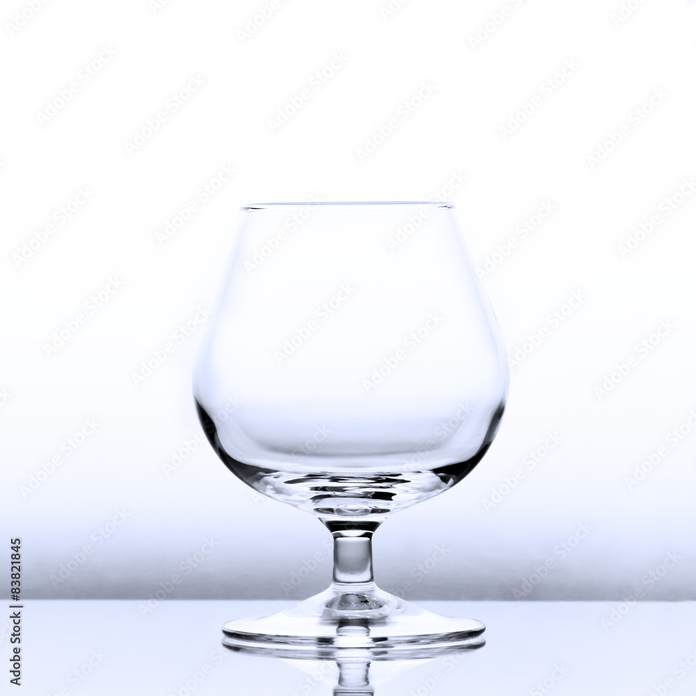 An empty cognac snifter in slightly blue light with a reflection An empty cognac snifter in slightly blue light with a reflection