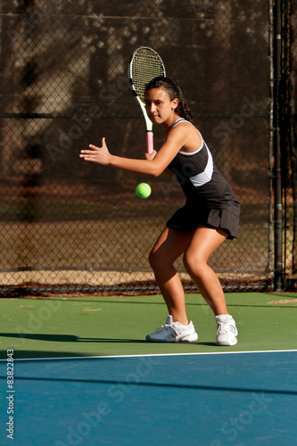 Female High School Tennis Player Prepares To Hit Forehand © blueiz60