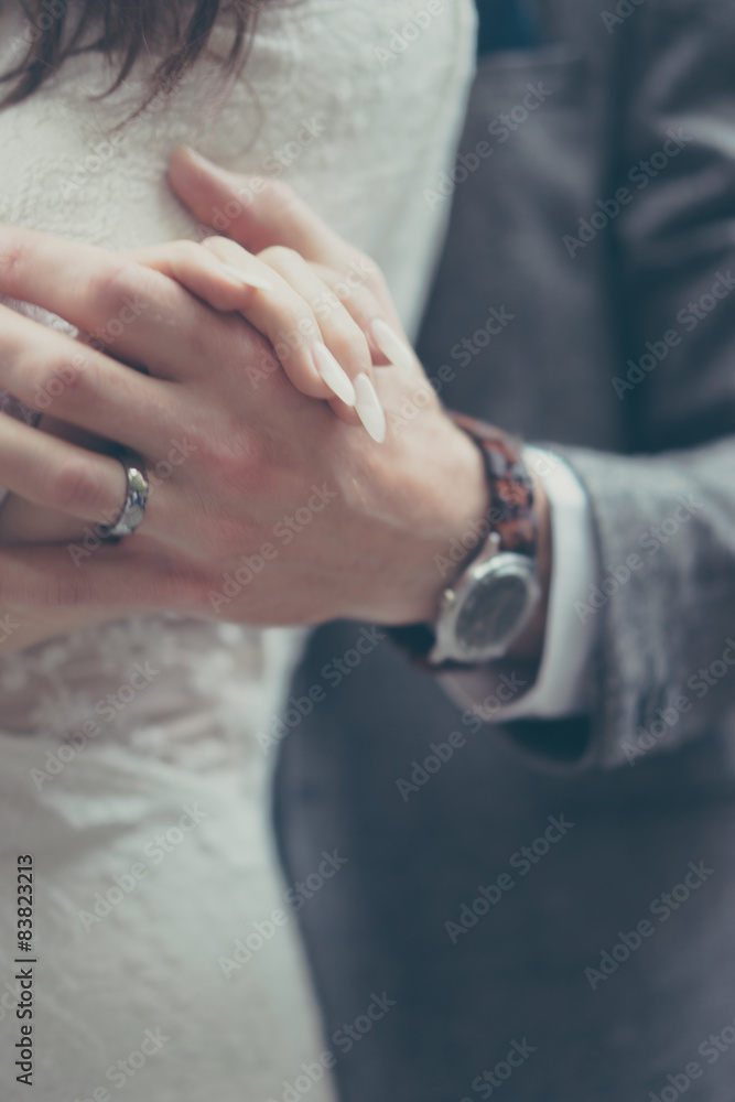 Fototapeta premium Bride and groom holding hands in vintage pastel colors