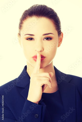 Businesswoman with finger on her lips