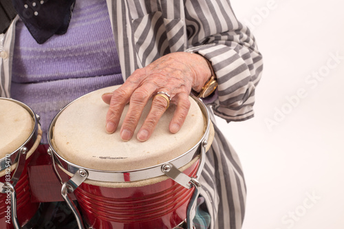 Funny elderly lady playing bongo.