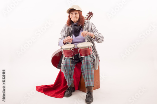 Funny elderly lady playing bongo.