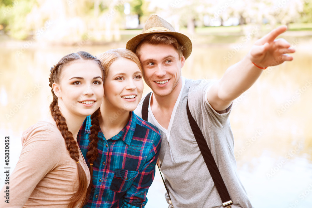 Handsome man with two girls pointing aside Handsome man with two girls pointing aside