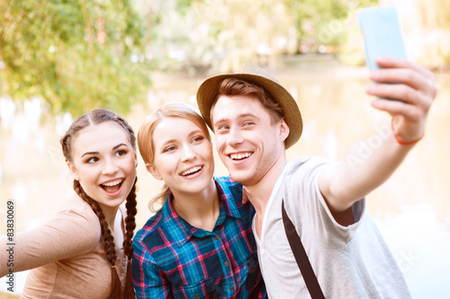 Three young people doing selfie in park