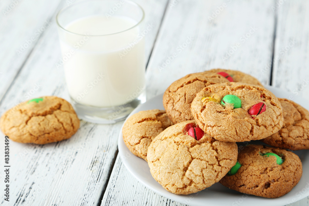 Cookies with colorful candy in plate on white wooden background Cookies with colorful candy in plate on white wooden background