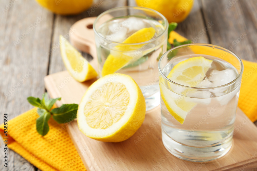 Fresh lemonade with lemon on grey wooden background Fresh lemonade with lemon on grey wooden background