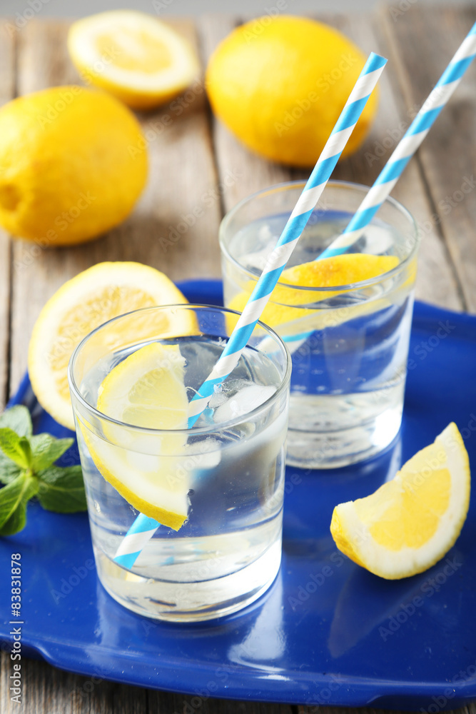 Fresh lemonade with lemon on grey wooden background Fresh lemonade with lemon on grey wooden background