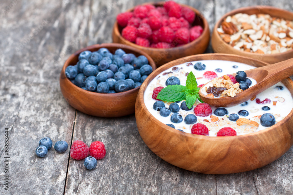 healthy breakfast muesli with berries and milk in wooden plate healthy breakfast muesli with berries and milk in wooden plate