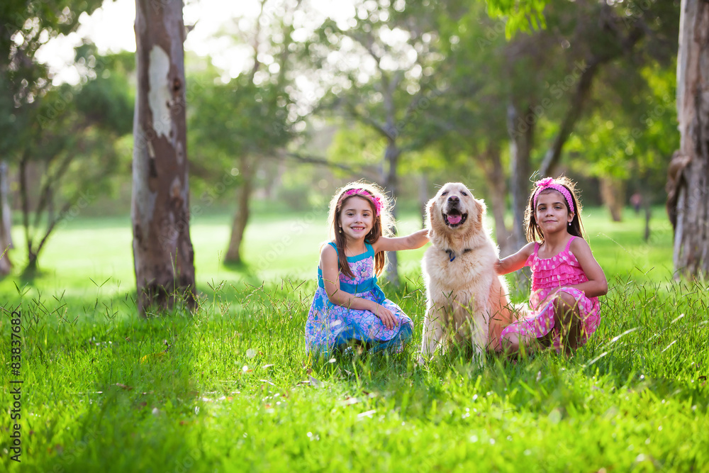 Two Beautiful little girls and dog friend golden retriever in th
