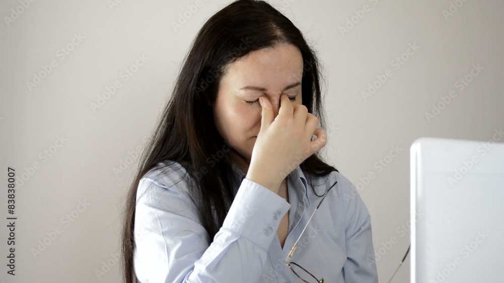 Woman in office with tired eyes and sore eyes Woman in office with tired eyes and sore eyes