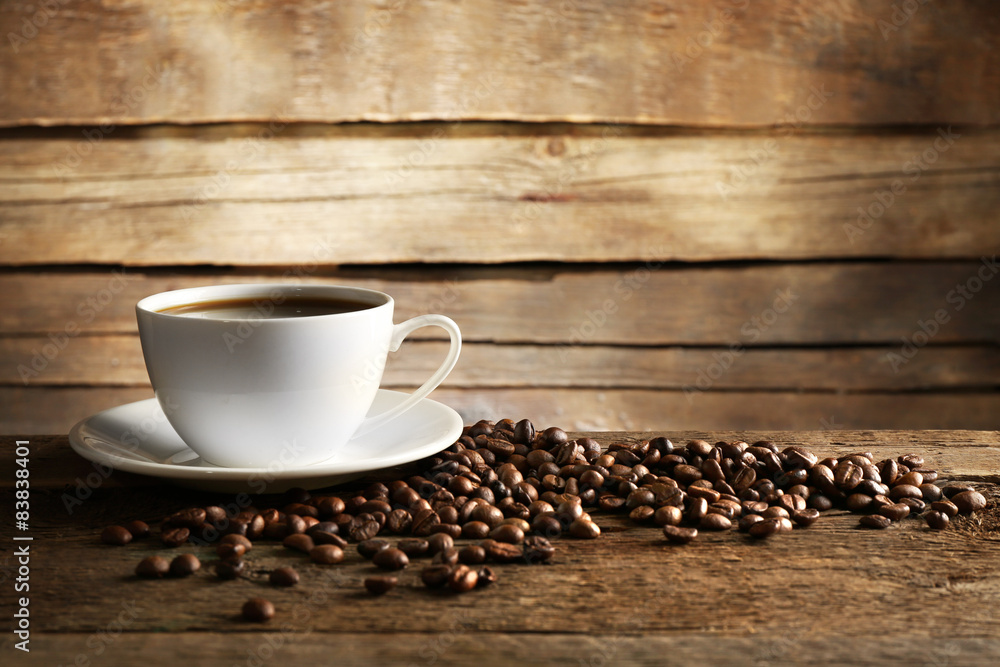 Cup of coffee with grains on wooden background Cup of coffee with grains on wooden background