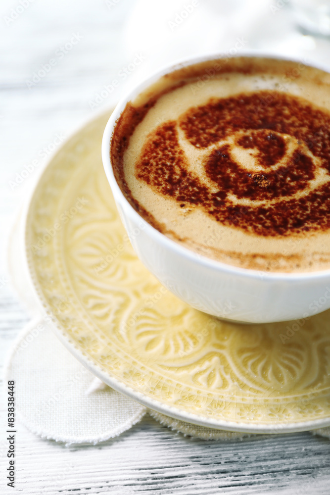 Cup of latte coffee art on wooden table, on light background Cup of latte coffee art on wooden table, on light background