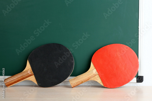 Table tennis rackets on blackboard background