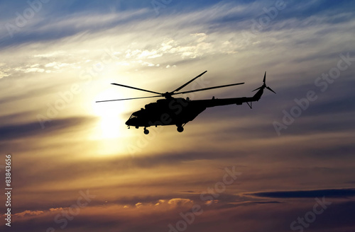 Picture of helicopter at sunset. Silhouette of helicopter on sun