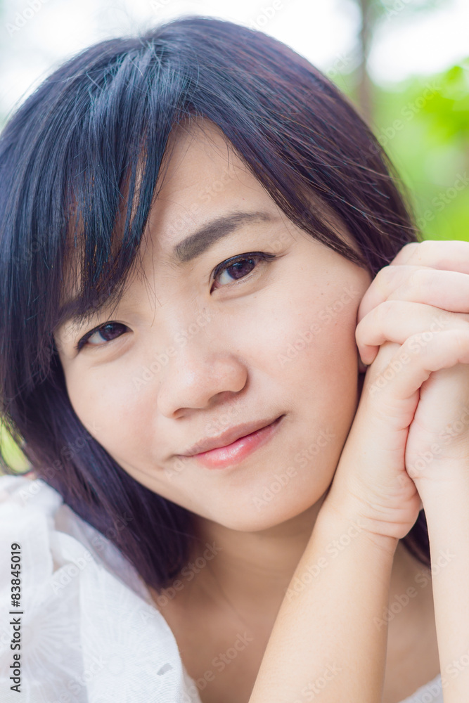 Portrait of young smiling Asian woman in park Portrait of young smiling Asian woman in park