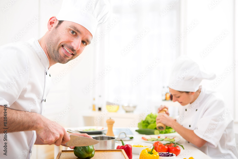 Young attractive professional chef cooking in his kitchen Young attractive professional chef cooking in his kitchen