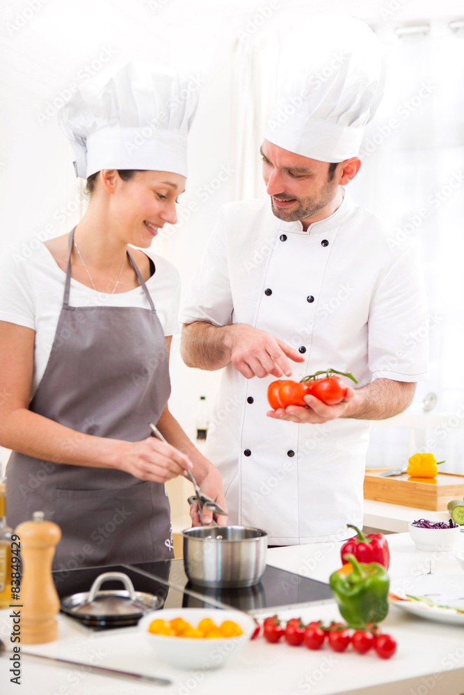 Young chef training a young attractive girl to cook Young chef training a young attractive girl to cook