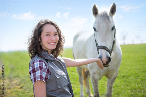 Portrait of a young attractive veterinary in fields with horse