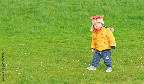 Toddler in park on green grass background