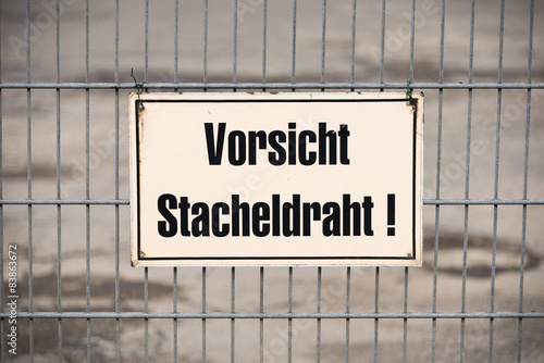 Labeling on a fence, warning of barbed wire, in the port Hamburg