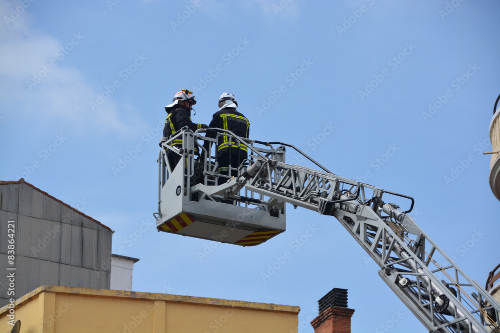 Obraz premium bomberos trabajando sobre una grua