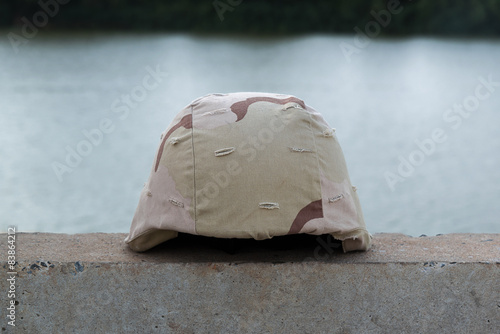 Fotografia A military helmet of desert camouflage  with river background