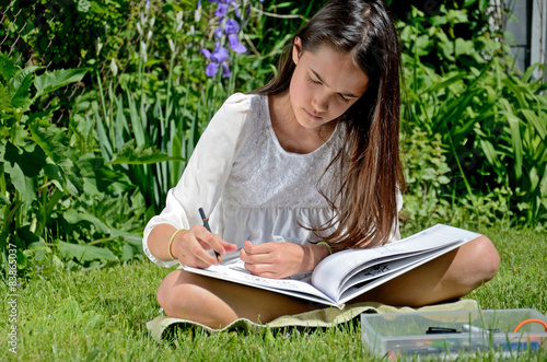 Little Hispanic Girl Draws in an Urban Garden