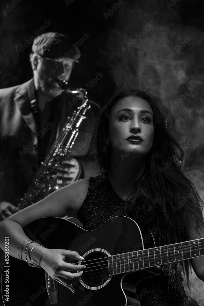 Obraz premium Lady guitarist with a saxophonist