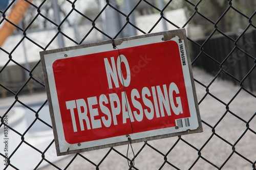 Red No Trespassing Sign On Fence