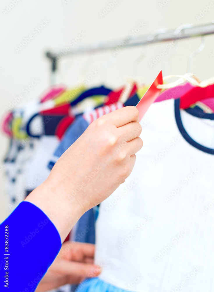 Woman's hand choosing child dress at clothing store. Woman's hand choosing child dress at clothing store.