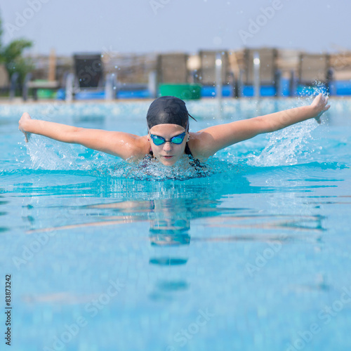 Young girl swimming butterfly stroke style