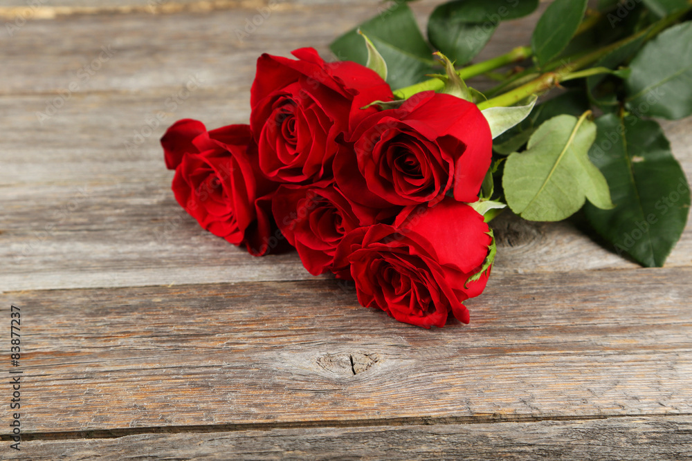 Five fresh red roses on grey wooden background Five fresh red roses on grey wooden background